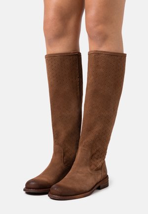 Bottes en suède marron jusqu'au genou avec un motif texturé, des bouts ronds et des semelles marron robustes. Conçues pour un ajustement confortable et des accents simples.