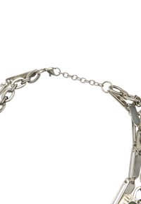 Srebrny metalowy łańcuch z naprzemiennymi owalnymi i okrągłymi ogniwami, z zapięciem i teksturowanym wykończeniem. Ogólny design jest skomplikowany i szczegółowy.