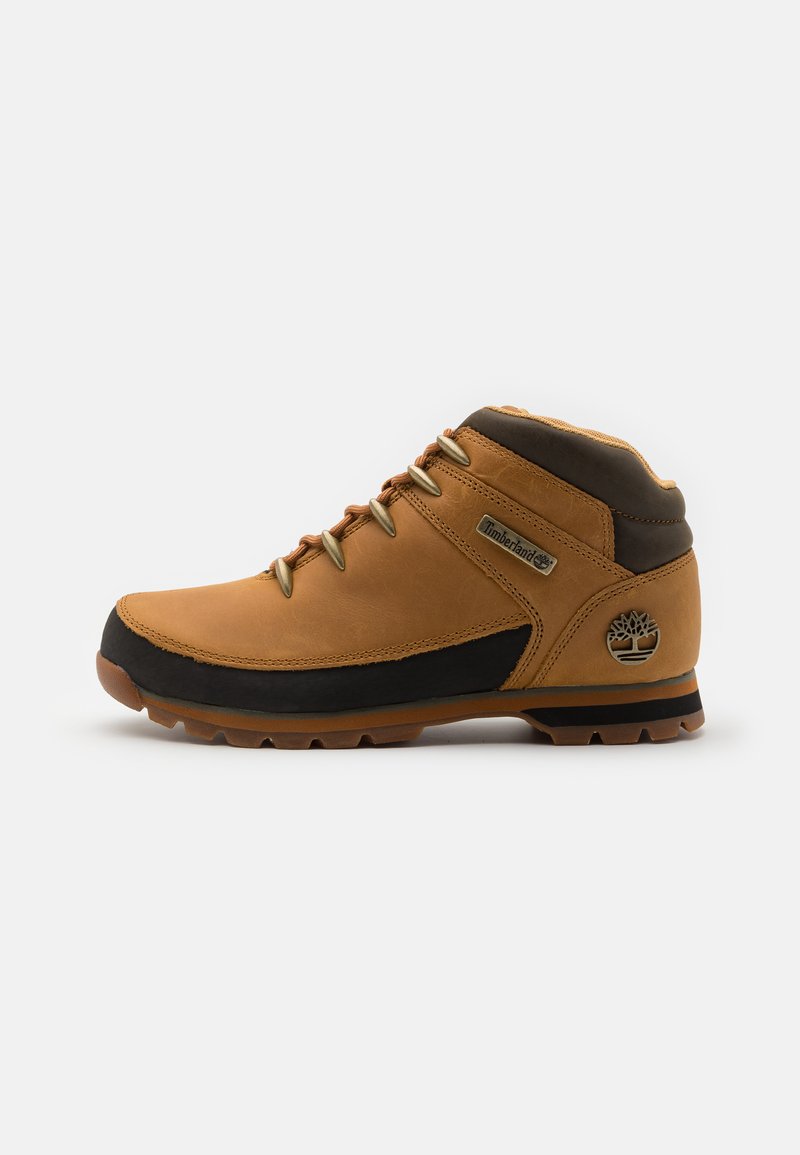 Brune lærstøvle til vandreture med sorte detaljer, struktureret overdel, polstret krave og gummisål med klodser til greb. Timberland-logoet er vist.