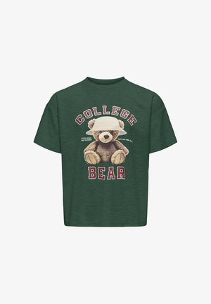 Zielona koszulka z grafiką niedźwiedzia noszącego kapelusz, z napisem "KOLĘDOWY NIEDŹWIEDŹ" oraz "Ucz się mocno, śpij jeszcze mocniej" w pogrubionych ciemnoczerwonych literach.