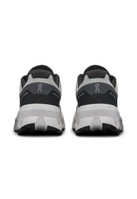 Black and gray athletic shoes with a cushioned heel, light gray outline, and textured sole featuring black rubber traction areas.