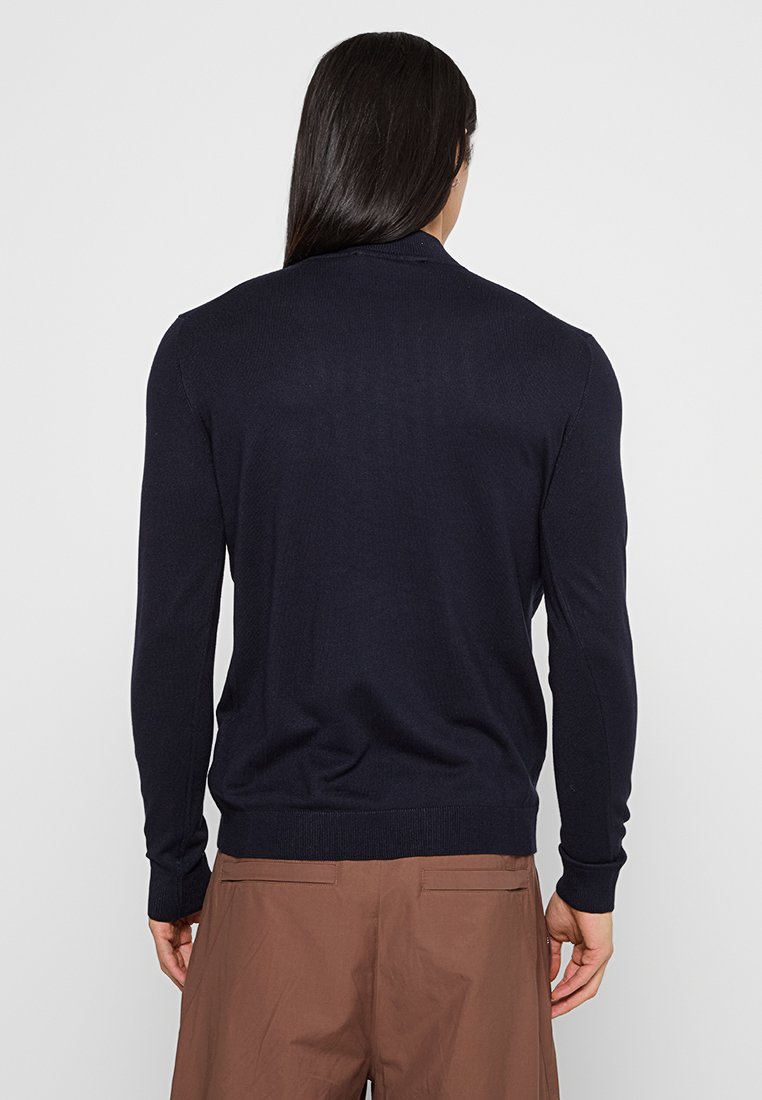 Marineblaues Strickpullover mit langen Ärmeln, gerippten Bündchen und Saum sowie einer weichen Textur. Die Rückansicht zeigt ein glattes, figurbetontes Design.