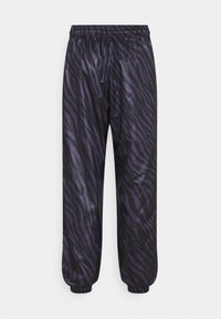 Pantaloni jogger con stampa a righe zebra viola e nera, dotati di vita e polsini elastici, realizzati in materiale lucido e liscio. Presentano una vestibilità ampia e affusolata.