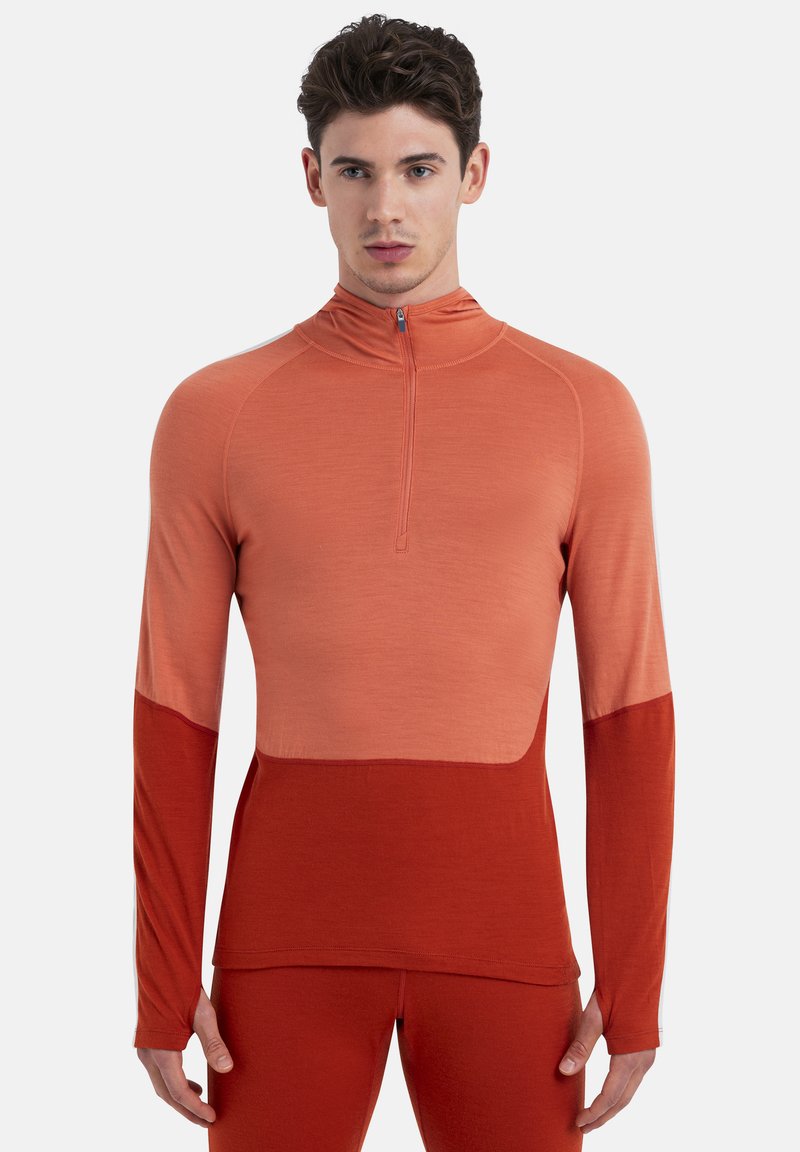 Maglietta atletica a maniche lunghe in gradiente arancione con collo a mezza zip. Presenta un pannello inferiore a contrasto e un design aderente. Tessuto morbido e traspirante.