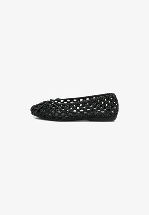 Bailarina negra trenzada con puntera redondeada, que presenta un detalle decorativo de nudo y una suela flexible. El material parece ligero y transpirable.
