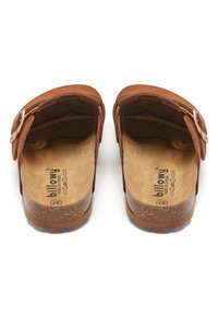 Sandales en suede marron avec un design ouvert, bride ajustable, semelle en liège et semelle en caoutchouc texturé. Marque visible sur les semelles intérieures.