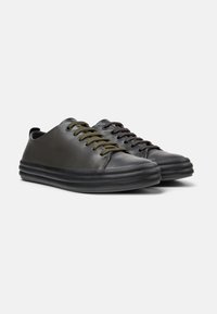 Schwarze Ledersneaker mit einer glatten Oberfläche, runder Zehenpartie und kontrastierenden olivgrünen Schnürsenkeln. Sie verfügen über eine dicke, strukturierte Gummisohle.
