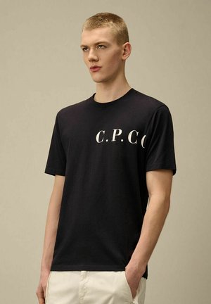 T-shirt in cotone nera con colletto tondo e maniche corte, stampata con "C.P.C.C." in bianco sulla parte anteriore. Design semplice e classico.