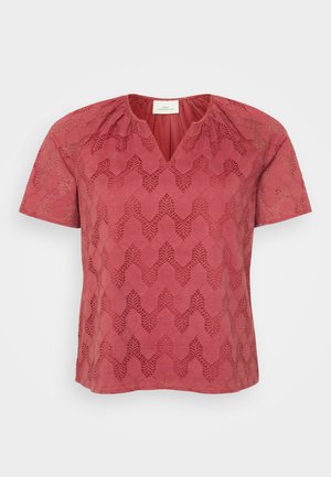 Rød kortærmet top med V-hals, prydet med et tekstureret geometrisk blonde mønster og samling ved skuldrene.