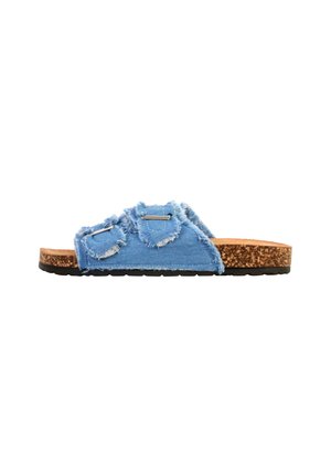 Slippersandaal met kurken zool en twee verstelbare lichtblauwe versleten denimriemen met metalen gespen op een witte achtergrond.