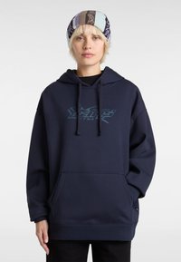 Hoodie oversize bleu marine en tissu doux, avec une poche frontale et un imprimé graphique en teal. Inclut un capuchon avec cordon de serrage réglable.