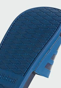 Sandale en caoutchouc bleu avec un fond texturé pour une meilleure adhérence, une sangle ajustable et des accents cousus pour plus de durabilité.