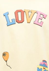 Έγχρωμα γράμματα σε σχήμα τετραγώνου που σχηματίζουν τη λέξη «ΑΓΑΠΗ», με ένα πορτοκαλί μπαλόνι και μια πολύστιχη τούρτα με καρδιά σε ανοιχτό φόντο.