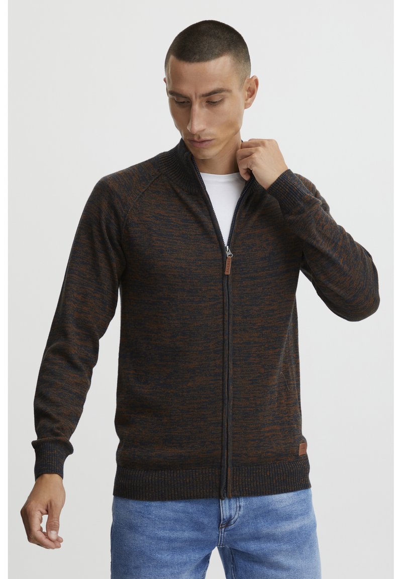 Mørkeblå og oransje melert strikket zip-up cardigan med ribbede mansjetter og hem, med et subtilt lærlogo-patch nederst til venstre.