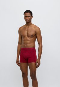 Κόκκινα ανδρικά εσώρουχα μπόξερ με σχέδιο και μονόχρωμη μέση με το λογότυπο "BJÖRN BORG" σε αντίθετο χρώμα. Κατασκευασμένα από μαλακό, ελαστικό υλικό.