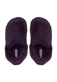 Zapatillas Crocs de color púrpura oscuro, difusas, con forma redondeada y textura suave y peluda. El interior cuenta con un forro negro y una etiqueta de logo visible.