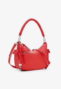 Borsa a tracolla in pelle rossa con forma curva, manico intrecciato e accessori in argento. Presenta tasche con zip e dettaglio del logo impresso.