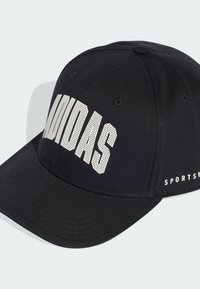 Gorra negra de tela con visera curvada. Presenta el logo blanco perforado de "ADIDAS" y el texto "SPORTSV" en el lateral.