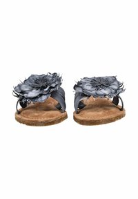 Sandales plates marron avec de grandes fleurs en tissu gris sur le dessus et des sangles noires, présentées de face sur un fond blanc.