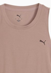 Débardeur rose clair à côtes avec un col rond et un logo Puma noir sur le côté gauche de la poitrine. Fabriqué à partir d'un tissu doux avec une finition texturée.