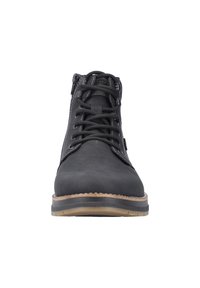 Bottines noires avec un dessus en cuir texturé, des coutures contrastées, un bout rond et une semelle en caoutchouc avec un accent marron clair.