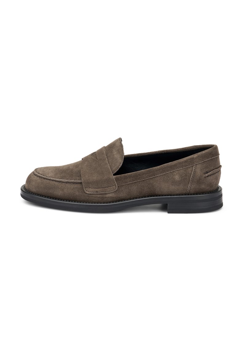 Mocassins en suede marron foncé avec un bout arrondi, présentant une sangle cousue sur le cou-de-pied et une semelle plate en caoutchouc noir.