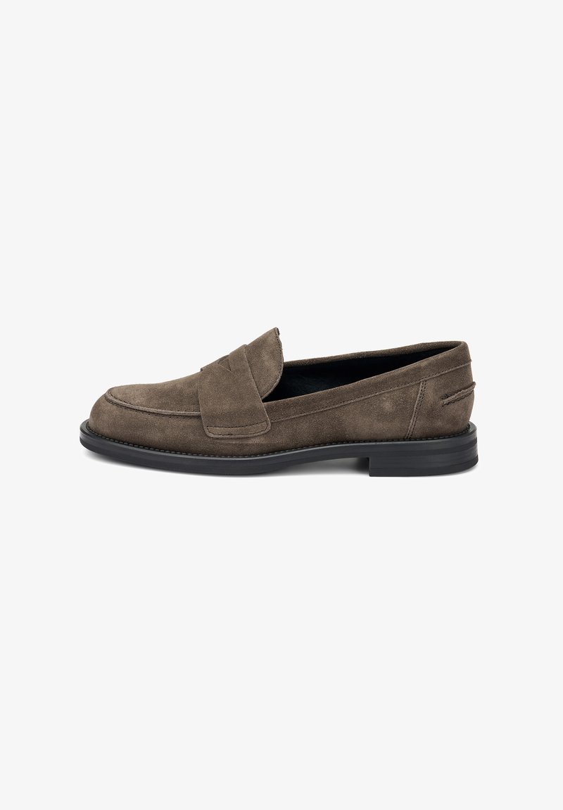 Mocassins en suede marron foncé avec un bout arrondi, présentant une sangle cousue sur le cou-de-pied et une semelle plate en caoutchouc noir.