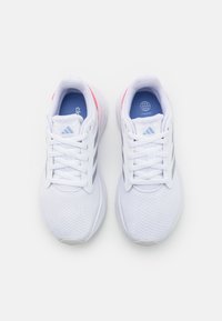 Un par de zapatillas de running Adidas blancas con rayas grises y plantillas azules, vistas desde arriba sobre un fondo blanco.