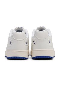 Białe skórzane sneakersy z płaską kremową podeszwą i niebieskimi akcentami. Posiadają okrągły czubek, wyściełany kołnierz oraz przeszywane detale po bokach.