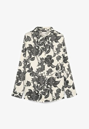 Hvid skjorte med lange ærmer og knapper, med sort indviklet blomstermønster og bladmønster over det hele.