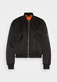 Veste bomber noire avec fermeture éclair frontale, poignets et ourlet côtelés, dotée de deux poches avant et d'une doublure intérieure orange. Texture lisse.