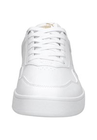 Sneakers bianchi in pelle con punta arrotondata, suola piatta in gomma e cuciture tonali. I lacci sono bianchi con un logo dorato sulla linguetta.