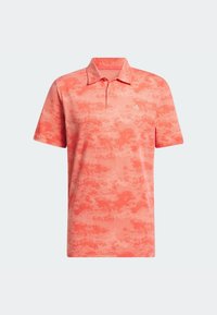 Lyhythihainen poolopaita korallin värisenä, jossa on teksturoitu, abstrakti kuvio. Paita on kauluksellinen ja vasemmassa rinnassa on kontrastivärinen logo.