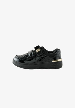 Schwarzer Sneaker mit niedrigem Schaft und glänzender Oberfläche, zwei Klettverschlüssen, gemusterten Nähten und goldenem Akzent an der Ferse.