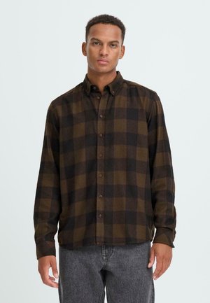 Chemise à carreaux avec des tons bruns et noirs, à manches longues et avec un col. Fabriquée dans un tissu doux et texturé, avec des boutons bruns.