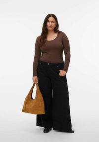 Bruin top met lange mouwen gecombineerd met losse zwarte broek met wijde pijpen, en een tan suède hobo tas in de hand. Kenmerkt zich door een eenvoudig ontwerp en een gladde textuur.