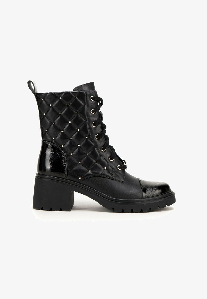 Bottines noires à la texture matelassée, ornées de clous dorés, de lacets noirs et d'un talon épais. Accents en vernis lisse sur l'avant et à l'arrière.