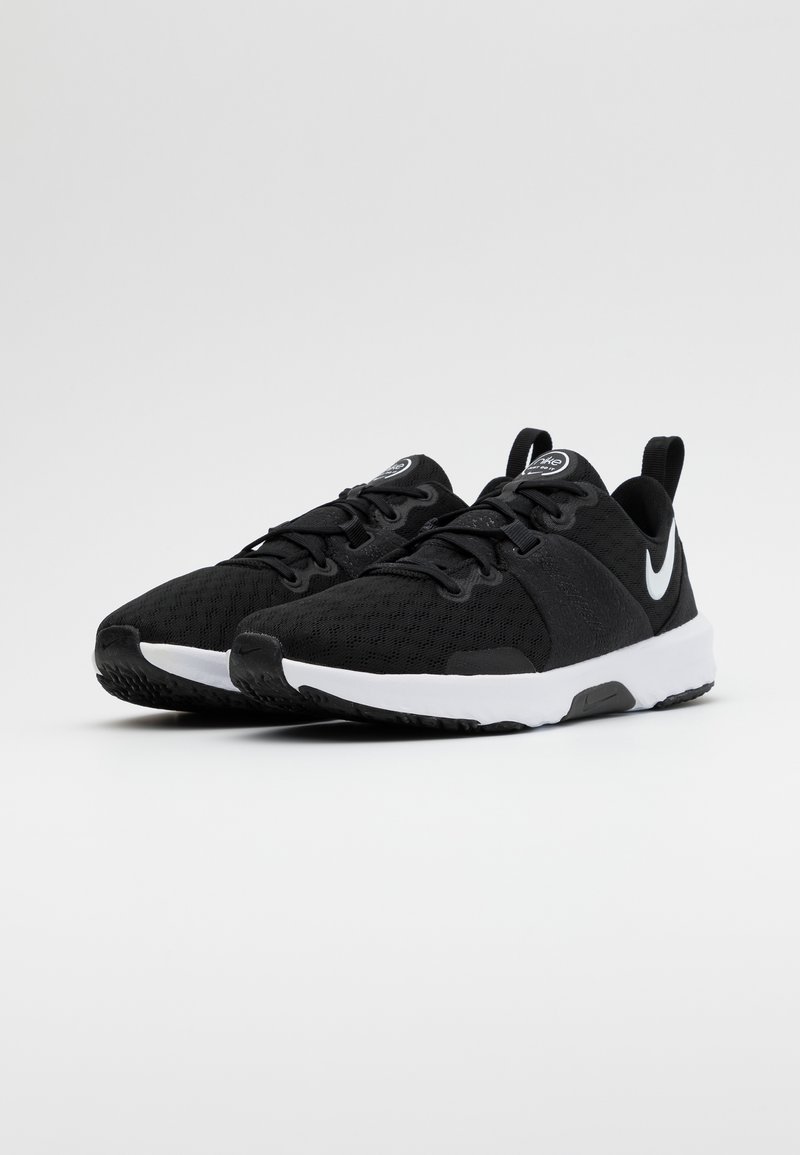 Zapatillas deportivas negras con una parte superior de malla texturizada, suela acolchada, acentos en blanco y un logotipo prominente en el lateral. Incluyen cordones y tiradores.