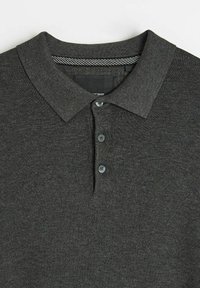 Ciemnoszara koszulka polo z fakturowanym kołnierzykiem, trzema guzikami i subtelnym paskowanym akcentem wewnątrz linii szyi.