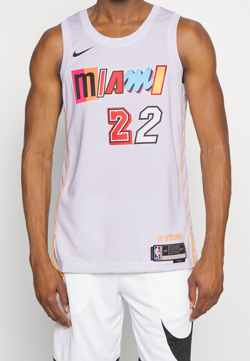Homme portant un maillot de basketball blanc de Miami avec un texte coloré "MIAMI" et le numéro 22, assorti à un short blanc avec un swoosh Nike noir.