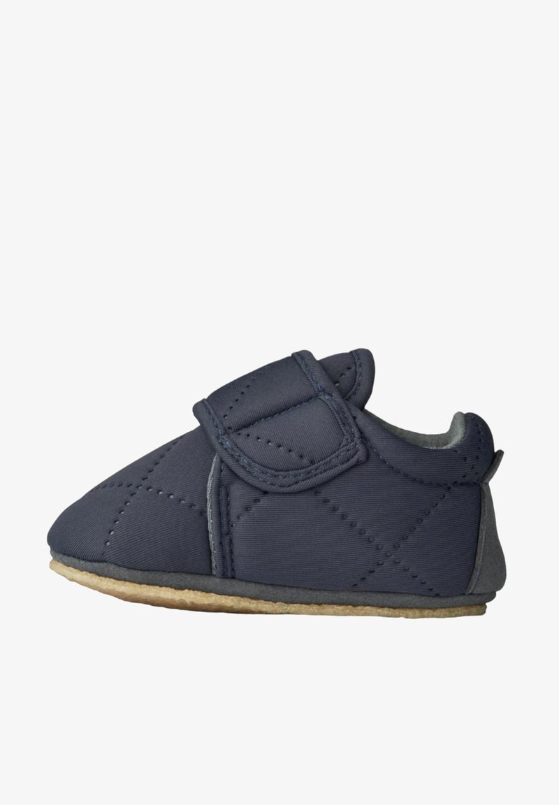 Chaussure pour bébé matelassée de couleur bleu foncé avec une sangle Velcro, doublée de doux gris et dotée d'une semelle en caoutchouc beige pour plus de traction et de confort.