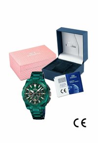 Orologio in metallo verde con quadrante multi-dial, cinturino in acciaio e accenti neri. Include una scatola blu e un imballaggio con motivo rosa. Documenti marchiati CE.