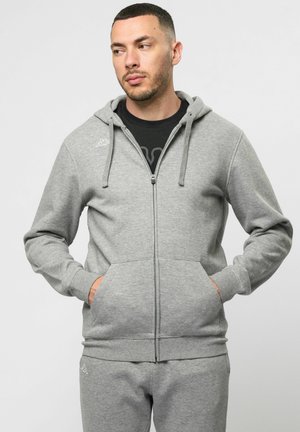 Graue Zip-Hoodie aus weichem Stoff, mit Kapuze, frontalen Taschen und slim Fit. Logo auf der linken Brust gestickt.