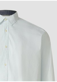 Camicia a righe azzurro chiaro con colletto button-down e bottoni gialli. Realizzata in tessuto liscio con trama verticale e accenti sottili.
