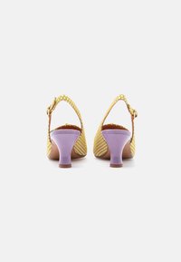 Κίτρινα παπούτσια slingback με πουά μοτίβο, που διαθέτουν χοντρό μύτη σε λεβάντα και διακοσμητικό αγκράφα. Λείο υλικό με στρογγυλεμένη μύτη.