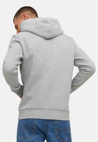 Grauer Kapuzenpullover mit lässiger Passform, gerippten Bündchen und Saum. Weicher, strukturiert Stoff mit Kängurutasche und flachen Nähten.