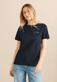 T-shirt en coton bleu marine à manches courtes, arborant un texte brodé vert "il paradiso" sur la zone gauche de la poitrine. Design à coupe décontractée.