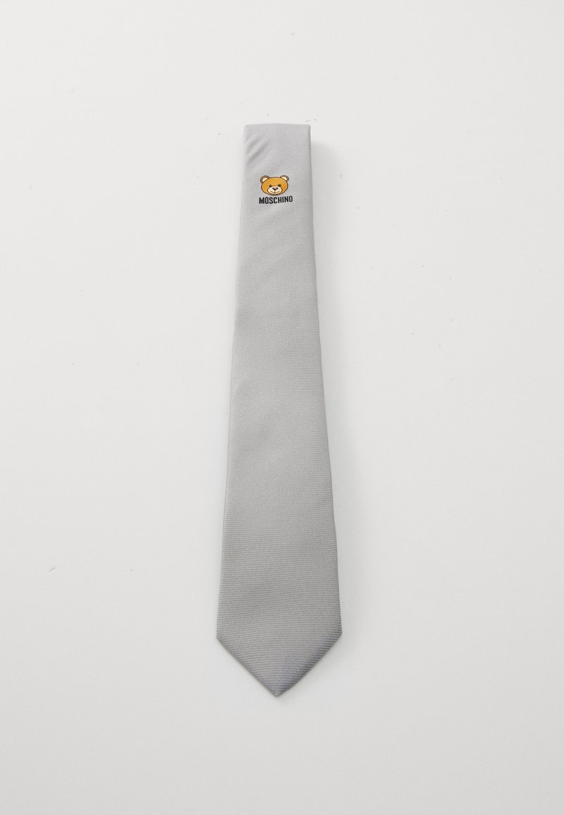 Gravata de seda cinza com uma superfície texturizada, apresentando um logotipo de urso e o texto "Moschino" perto da extremidade estreita.
