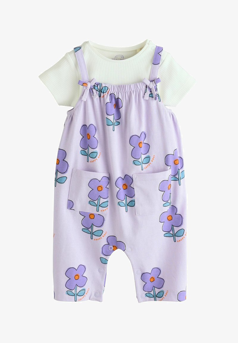 White short-sleeve baby shirt under light purple overalls with purple flower prints and front pockets, featuring green leaves and orange centers.