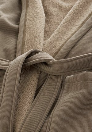 Beige badekåbe med en blød, tekstureret fleece-inderside, ribbet stofudvendig og en bundet bælte. Indeholder forlommer.